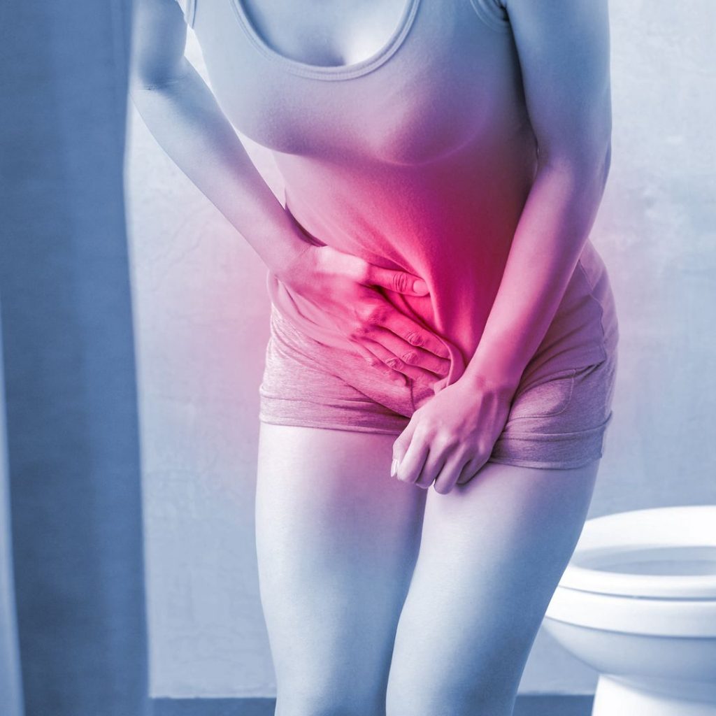 woman grabbing stomach with bladder problems from ibs 